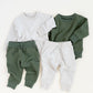 Two sets of children's clothing: a white sweatshirt with green pants and a green sweatshirt with white pants, on a white background.