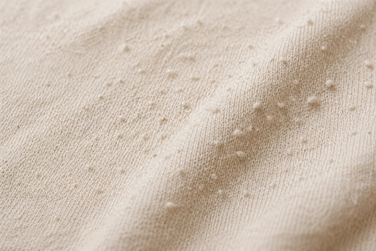 Folded soft baby clothes on a neutral blanket