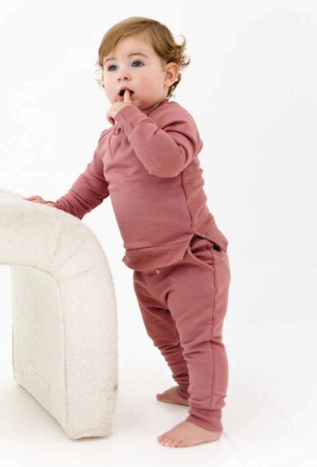 Child wearing a pink sweatshirt and pants set