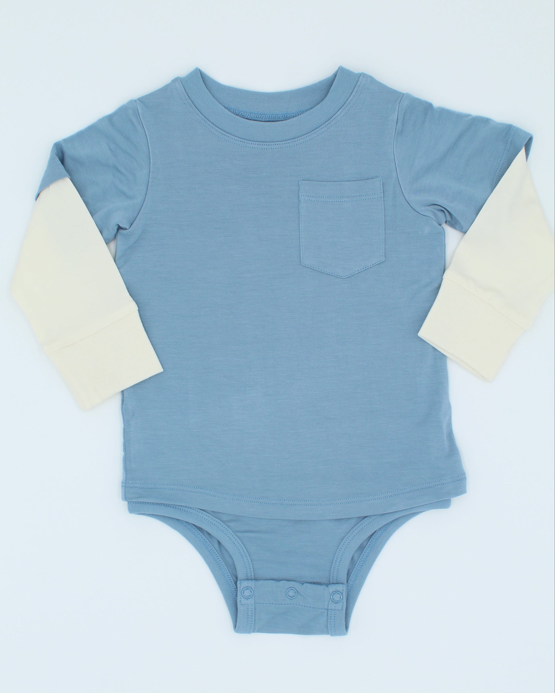 Blue baby onesie with cream sleeves on a light blue background