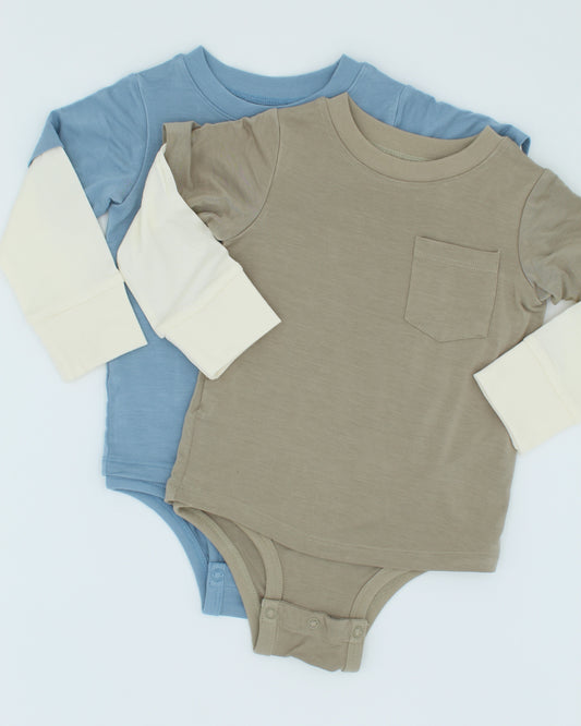 Two baby rompers, one blue and one beige, on a light blue background.