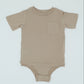 Beige baby onesie on a light gray background